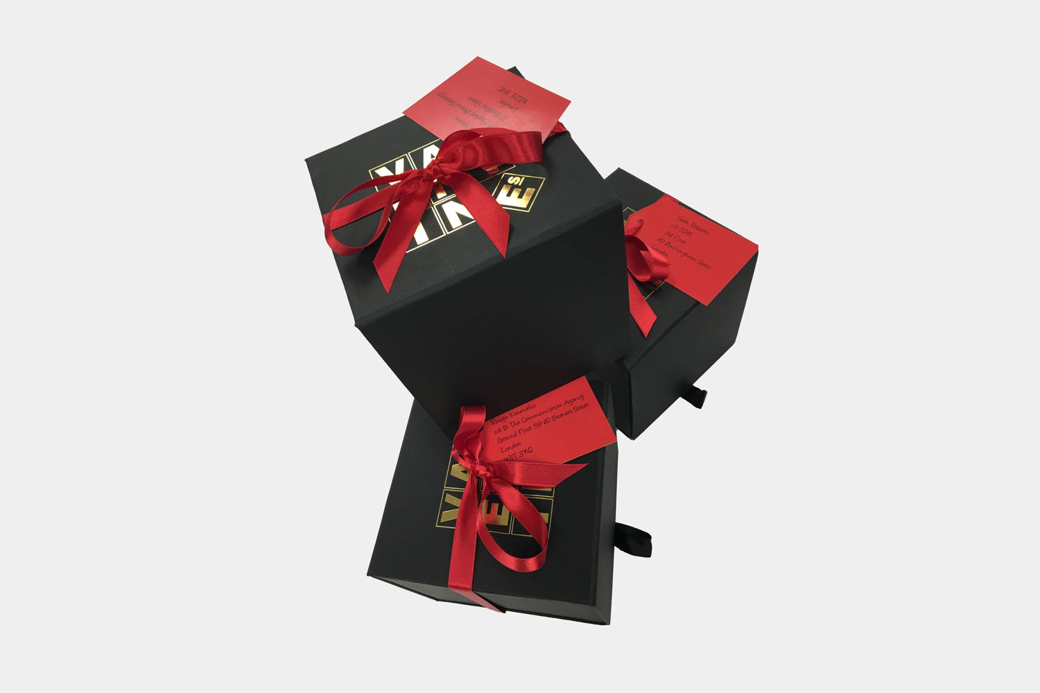 corporate gifting image with black boxes, gold logo and luxury red ribbon